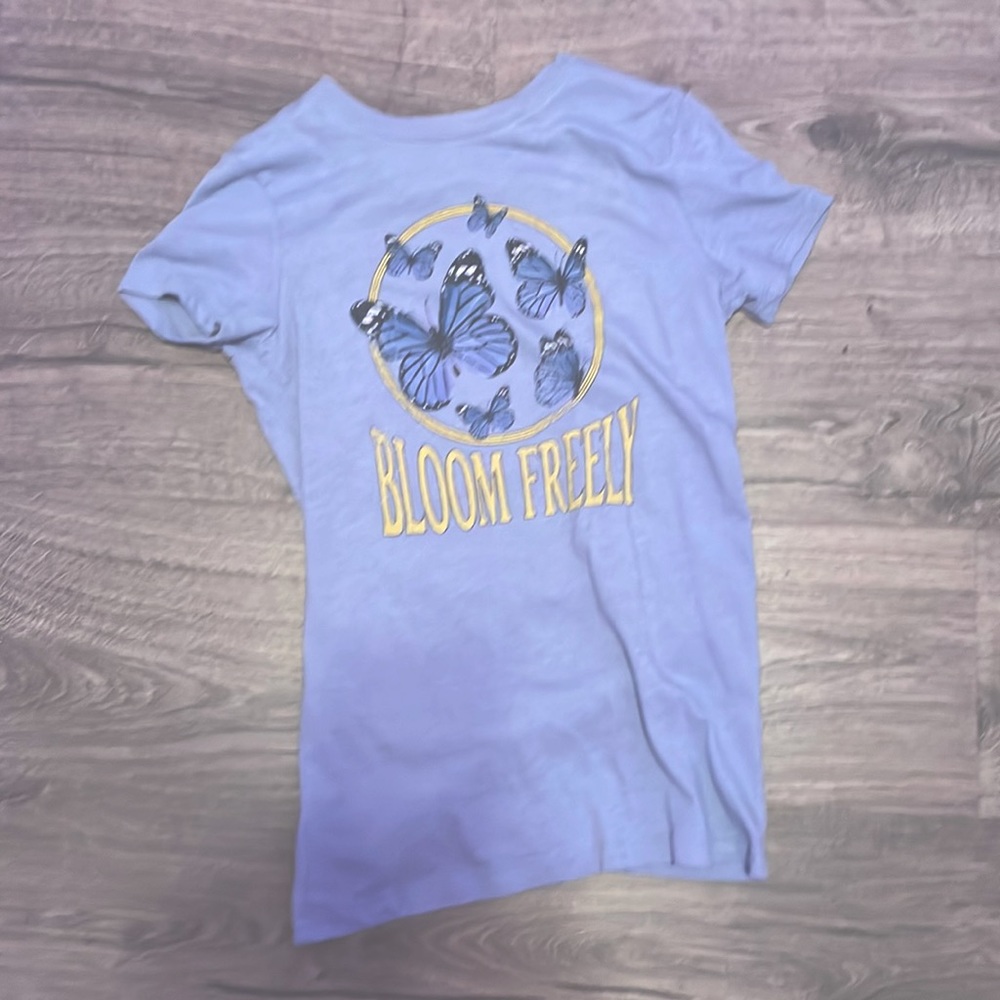 This blue shirt with text on it which says bloom freely, is a lightly used tee.